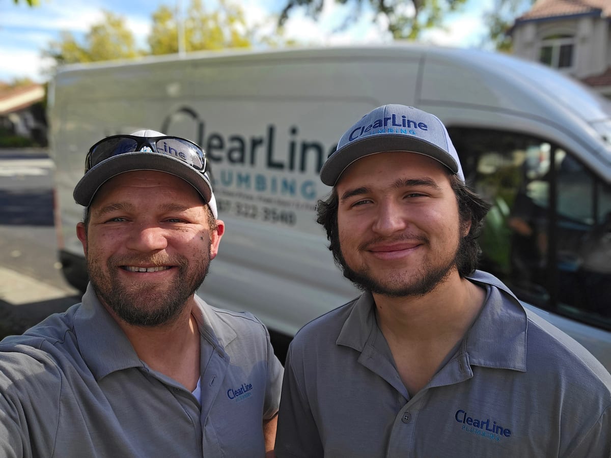 The ClearLine Plumbing team in matching uniforms in front of the company van